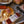 Load image into Gallery viewer, Assorted deli meats and cheeses on a wooden cutting board with striped towel underneath.