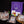 Load image into Gallery viewer, A packaged meat gift set displayed on a black background, including three vacuum-sealed cuts of beef with labels, a purple reusable bag with a white logo, small gift cards, a yellow bottle, and greenery with red berries.

