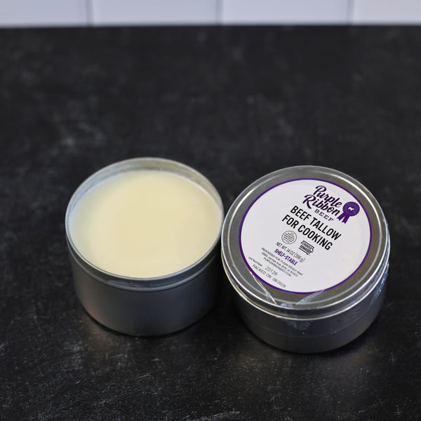 Purple Ribbon Beef cooking tallow in an open tin beside its labeled 14 oz container